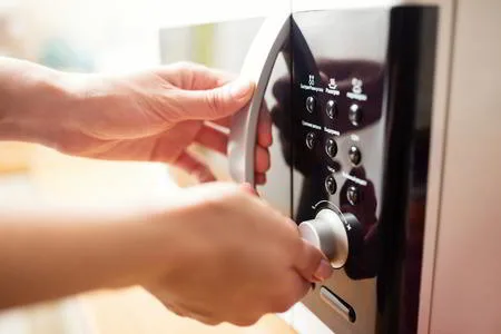 Female Hand Using Microwave