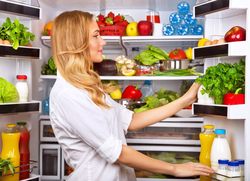 Happy Female Opening Refrigerator Full Of Fresh Fruits And Vegetables