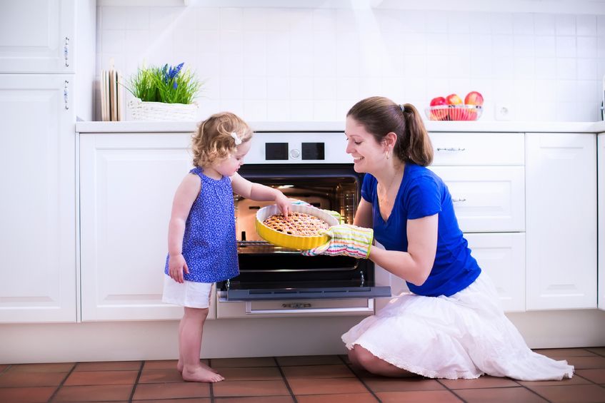 Mother And Child Baking A Pie In Front Of Oven