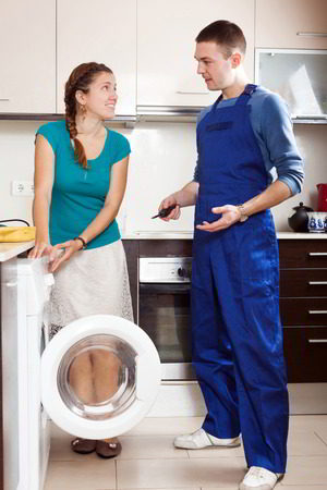 Sparkle Appliance Male Technician Talking To Housewife In Kitchen