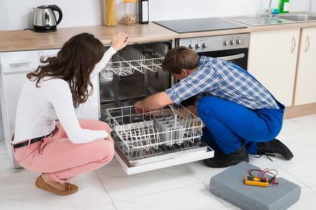Sparkle Appliance Repairman Fixing Dishwasher Not Draining With Housewife