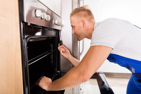 Sparkle Appliance Repairman Working On Canton Oven Repair In Kitchen