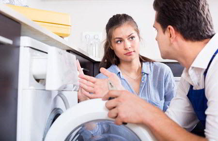 Sparkle Appliance Worker Repairing Washer With Housewife