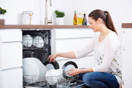 Young Woman Emptying Out The Dishwasher